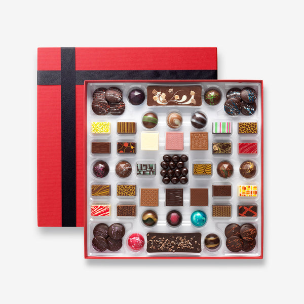 A box of 45 artisan chocolates including hot chocolate buttons, mini chocolate bars, and chocolate covered coffee beans colourfully decorated
