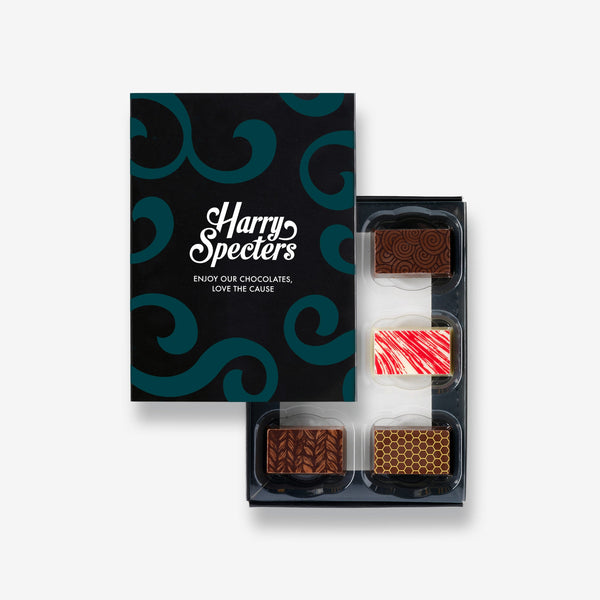 A box of 6 artisan chocolates partially covered by a box lid featuring the name Harry Specters