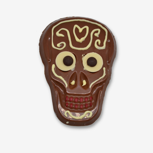 A milk chocolate skull decorated with white chocolate and colourful cocoa butter for Halloween