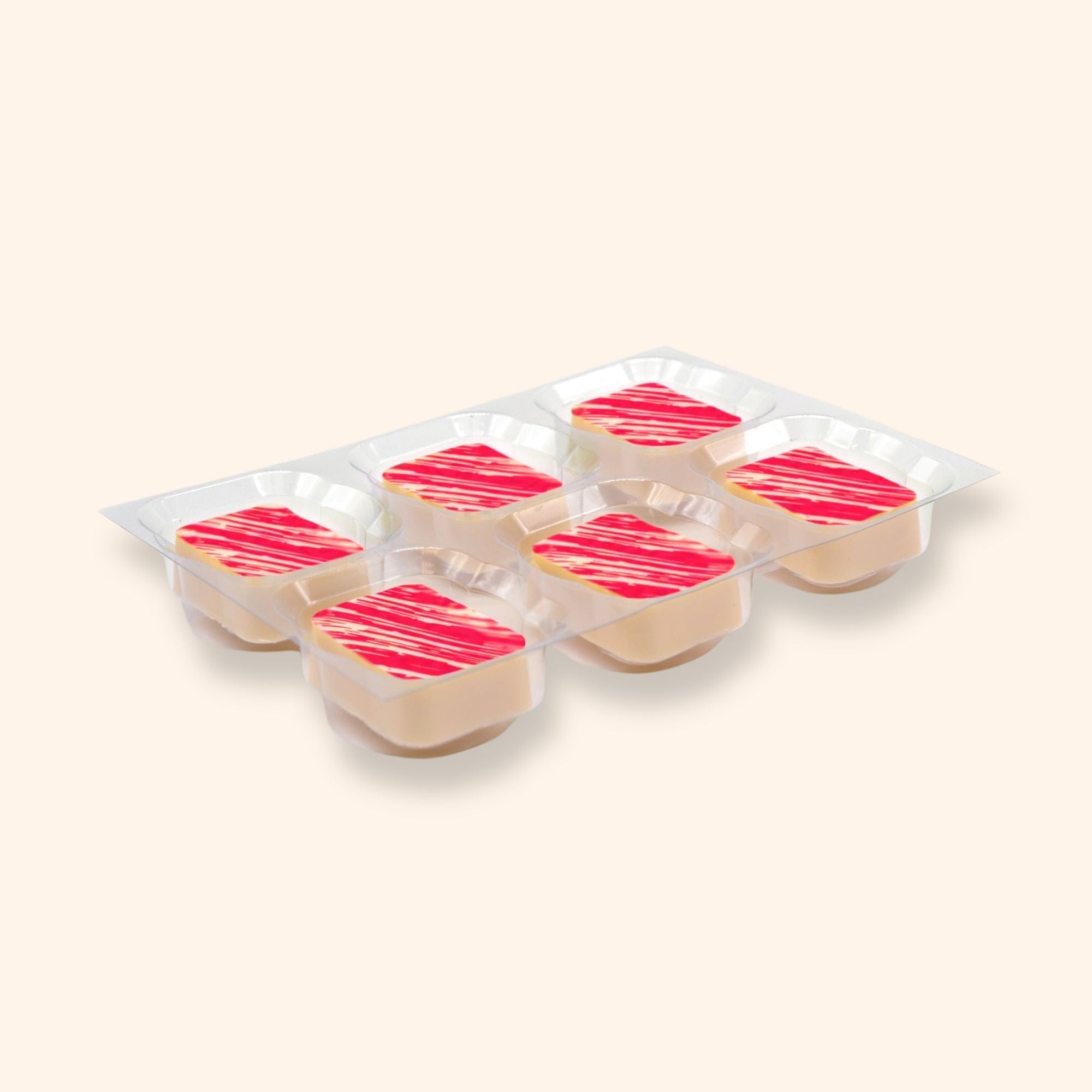 A tray of white strawberry cheesecake chocolates in a clear plastic tray