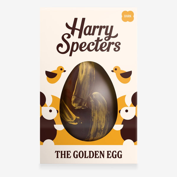 A dark chocolate Easter egg decorated with gold brush strokes in a colourful box with an Easter bunny design