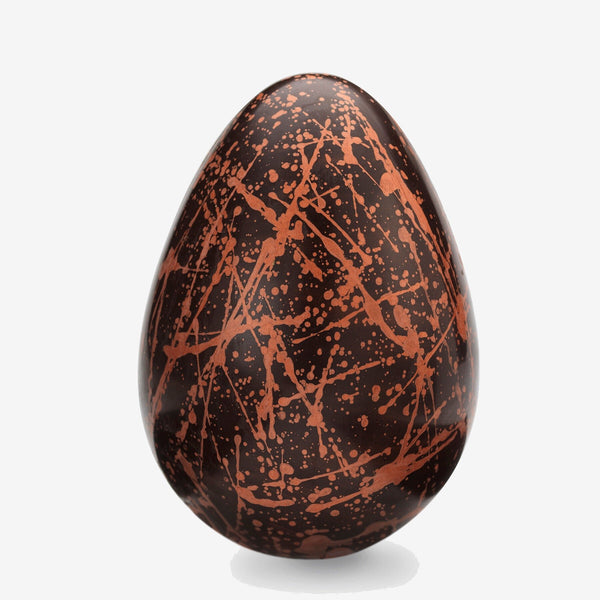 A milk chocolate Easter egg decorated with red splatter