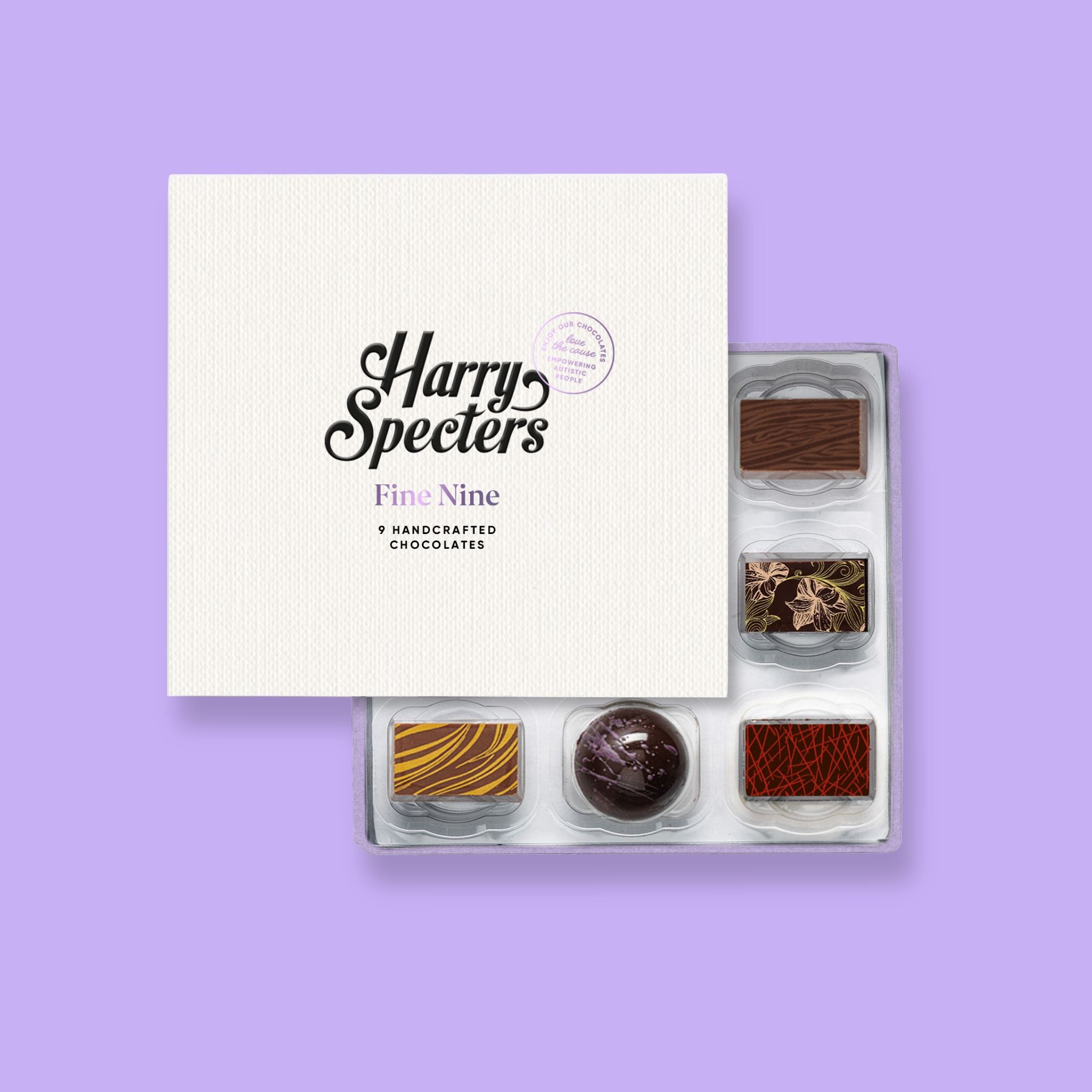 A box of 9 artisan chocolates by Harry Specters including Valentine's Day themed designs partially covered by a box lid 