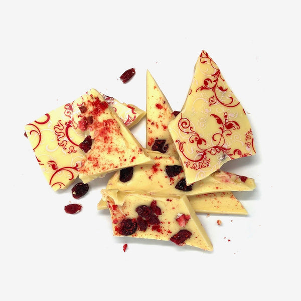 A pile of white chocolate shards with cranberries and freeze dried strawberries