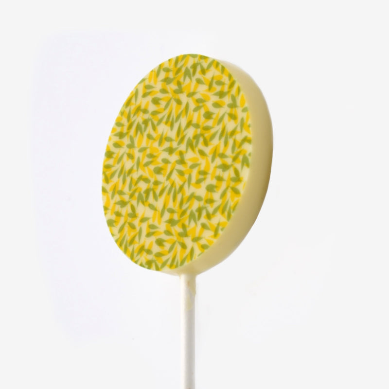 A white chocolate lollipop featuring a leaf design