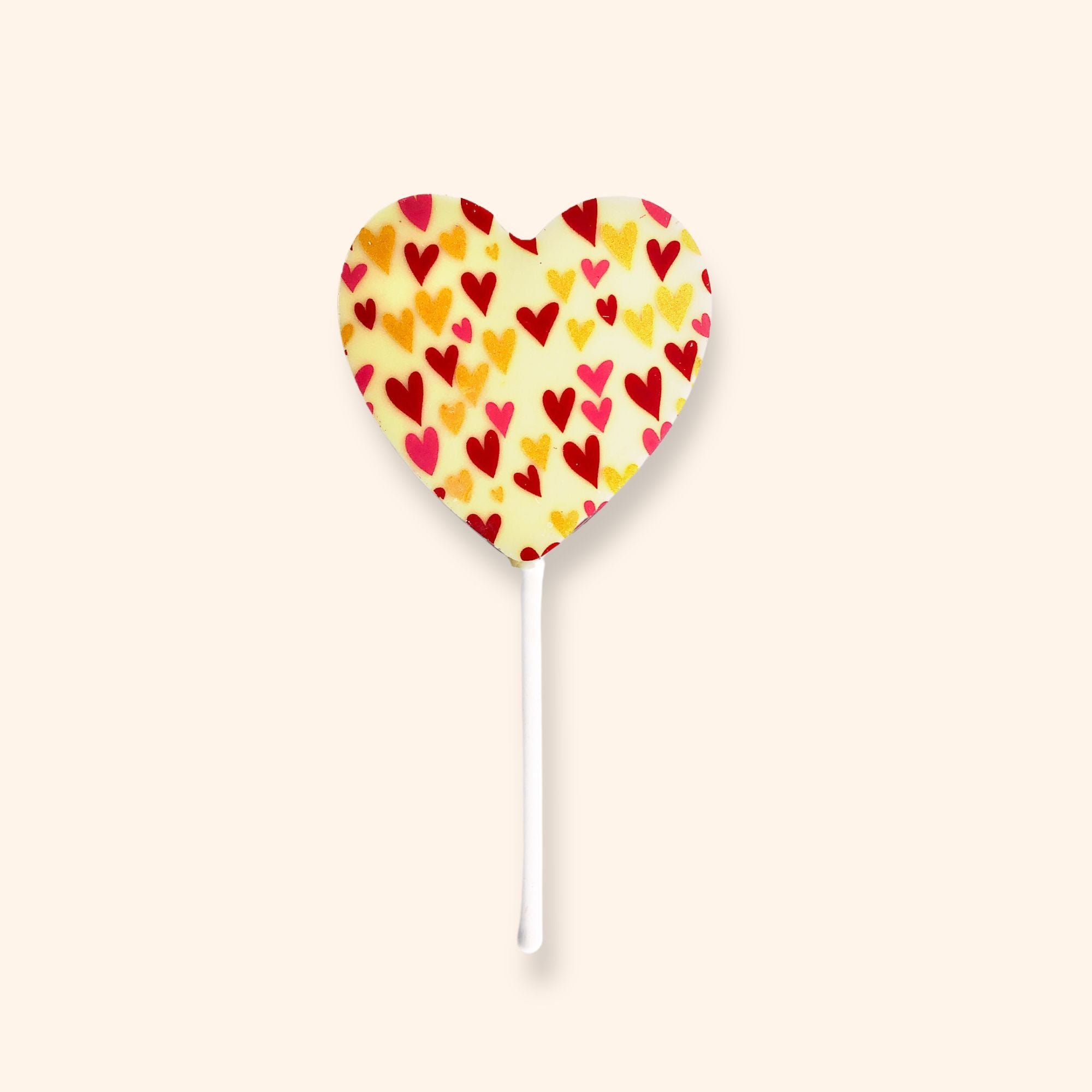 A heart shaped white chocolate lollipop featuring a colourful heart design